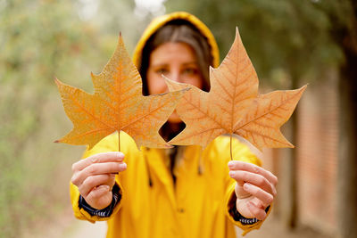 Cropped hand of woman holding autumn leaf