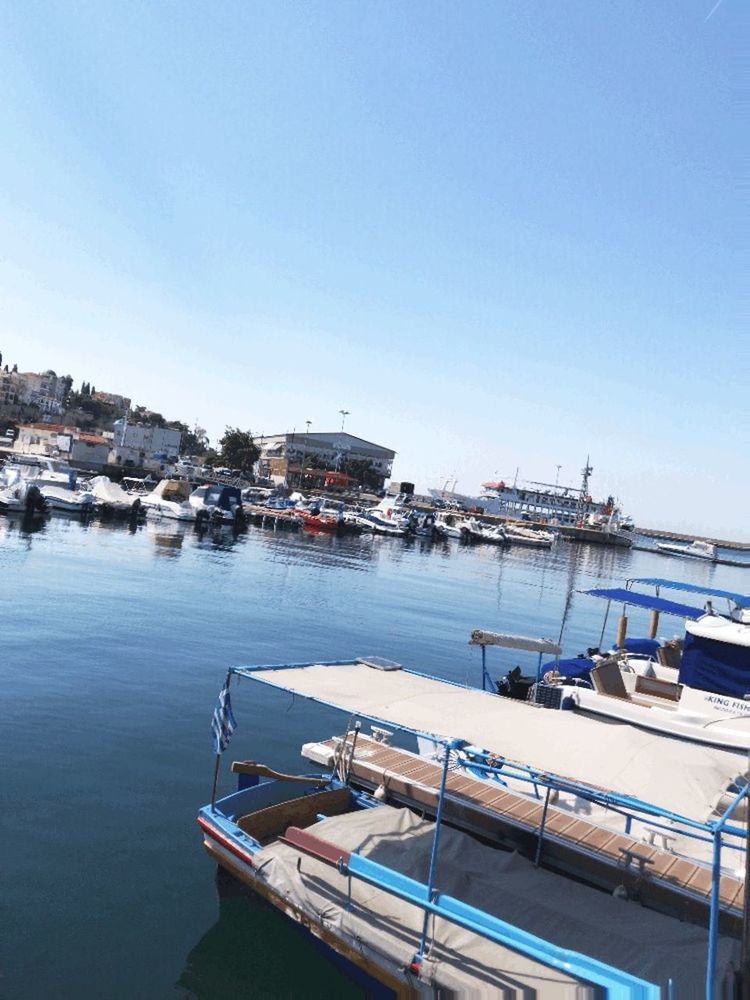 BOATS MOORED AT HARBOR AGAINST CLEAR SKY