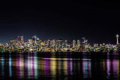 Illuminated buildings against sky at night