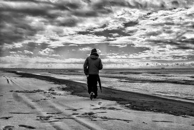 Rear view of man walking on beach