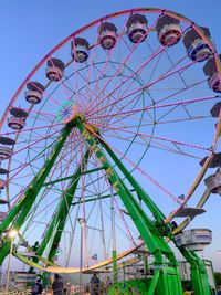 Low angle view of ferris wheel against blue sky