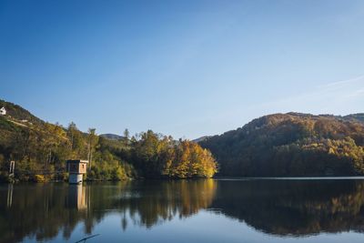 Scenic view of lake by trees against clear sky