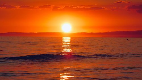 Scenic view of sea against romantic sky at sunset