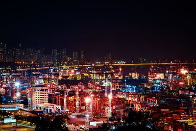 High angle view of illuminated buildings against sky at night