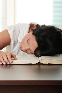 Woman sleeping on table at home