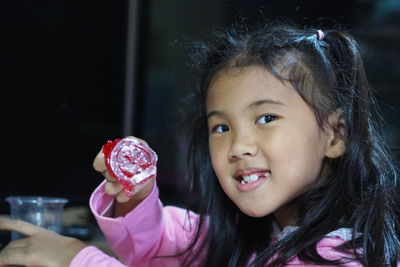Portrait of cute girl holding pink flower