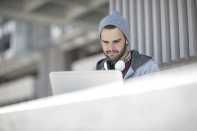 Young man using laptop outdoors