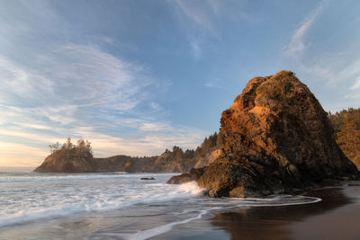 Rock formation on beach against sky