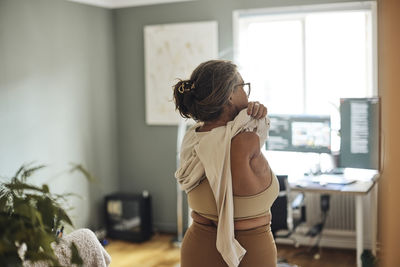 Rear view of mature woman with disability wearing dress at home