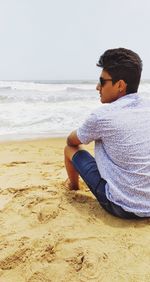 Young man sitting at beach