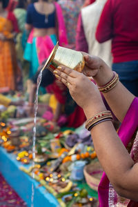 Holy water offerings by indian devotee doing traditional rituals at chhath festival at morning