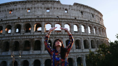 Full length of woman standing at historical building