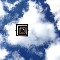 Directly below shot of street light against cloudy sky