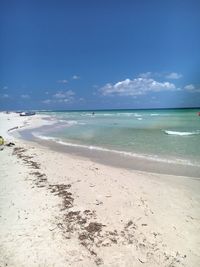 Scenic view of beach against blue sky