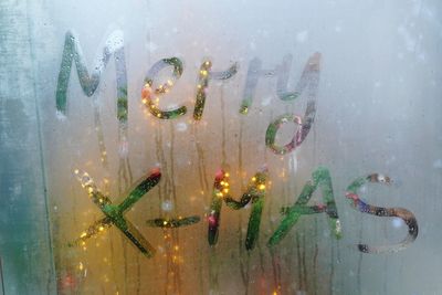 Full frame shot of wet glass window with christmas greetings 