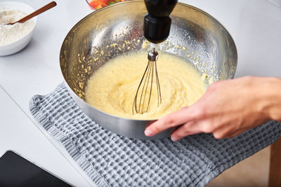 Woman in the kitchen cooking a cake. hands beat the dough with an electric mixer