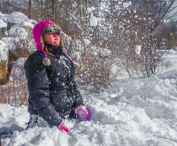 Girl throwing snow during winter
