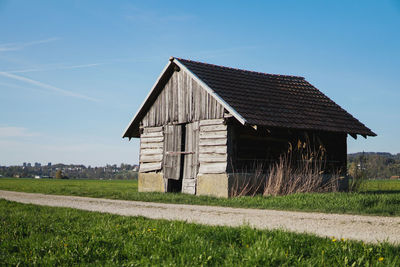 Barn on land against sky