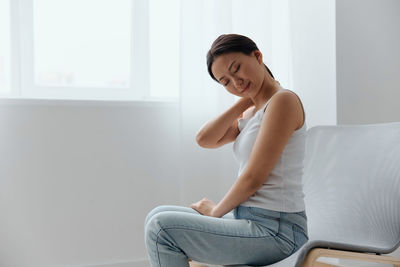 Young woman sitting on sofa at home