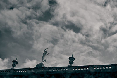 Low angle view of birds on roof against sky