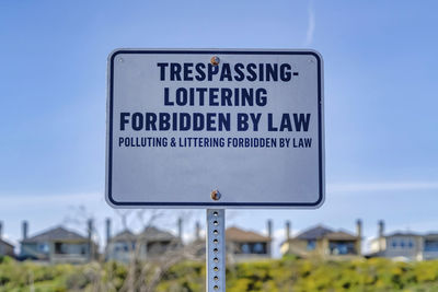 Close-up of road sign against blue sky