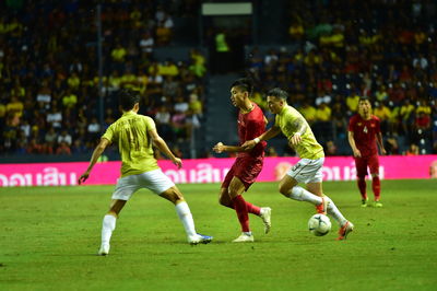 Group of people playing soccer ball on grass