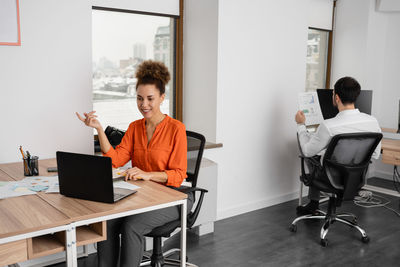 Businesswoman using laptop while sitting on table