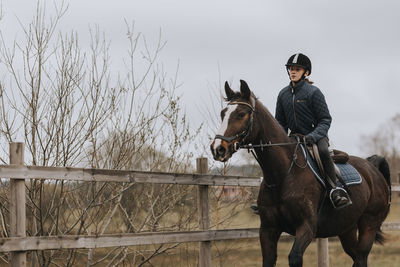 View of girl horseback riding