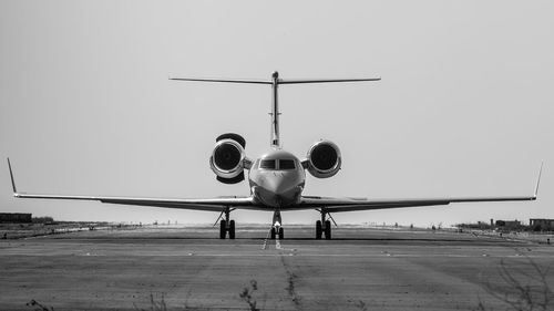 Airplane on runway against sky