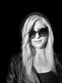 Portrait of smiling woman against black background