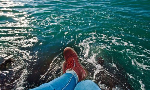 Low section of person standing in sea