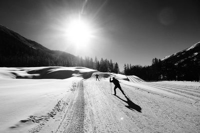 Silhouette people skiing on snow covered mountain