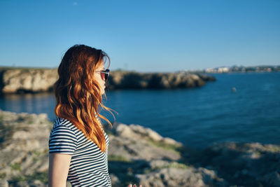 Woman looking at sea against sky