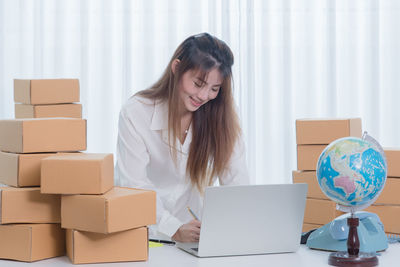 Young woman using mobile phone in box