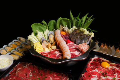 Close-up of fruits in plate against black background