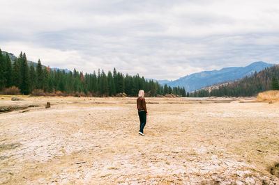 Woman standing on landscape against mountains