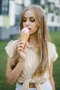 Young beautiful woman eats ice cream on a city walk on a sunny summer day on vacation