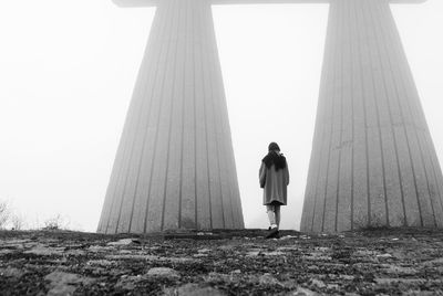 Rear view of woman walking on land against clear sky