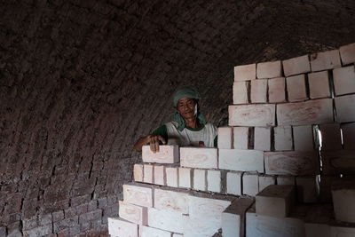 Man arranging bricks in tunnel