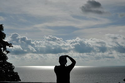 Rear view of silhouette man looking at sea against sky