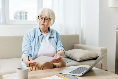 Portrait of young man using laptop at home