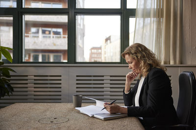 Side view of young woman using laptop while sitting at home