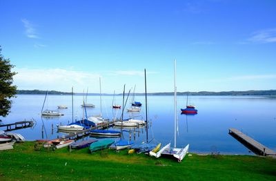 Boats in calm sea against clear sky
