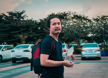 Man looking away while standing on footpath