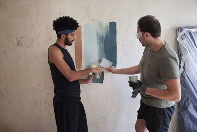 Gay couple renovating flat and choosing wall paint