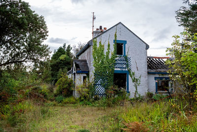 Abandoned house on field against sky