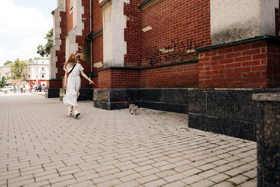 Rear view of woman walking on footpath