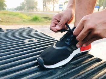 Low section of man tying shoelace outdoors