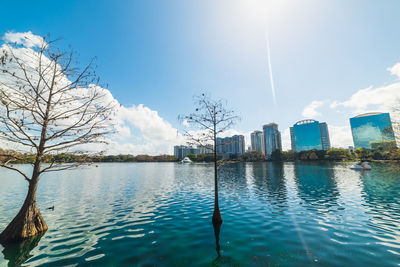 Scenic view of lake against sky in city