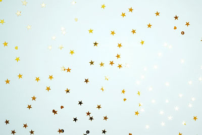 Low angle view of confetti against blue background